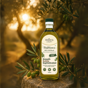 Bottle of Herbal Plaltter Hojiblanca Olive Oil Blend with olive leaves on a wooden stump.